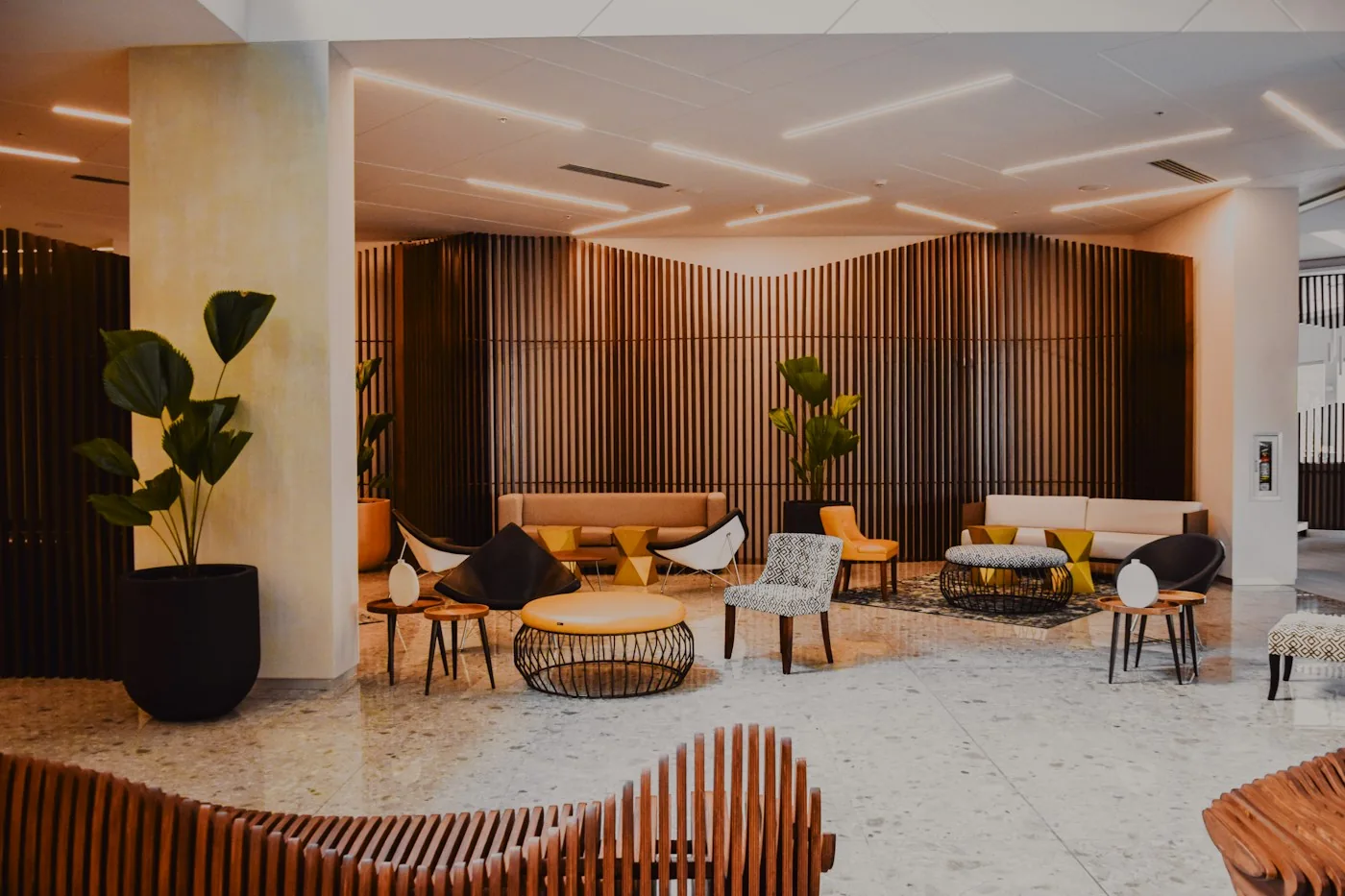 Moderne Hotellounge mit warmem Holz und Sesseln — Symbolbild